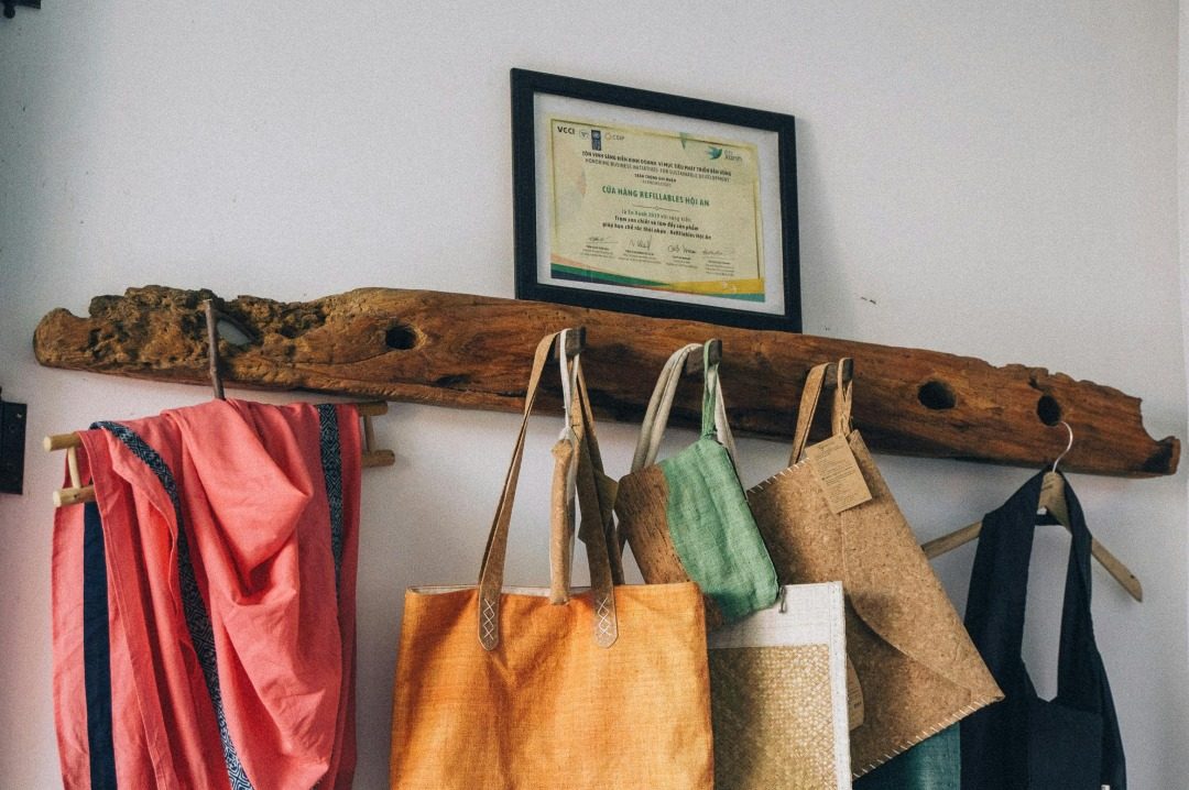 Photo by Anna Tarazevich: https://www.pexels.com/photo/reusable-shopping-bags-hanging-on-a-hanger-made-of-salvaged-wood-7771968/